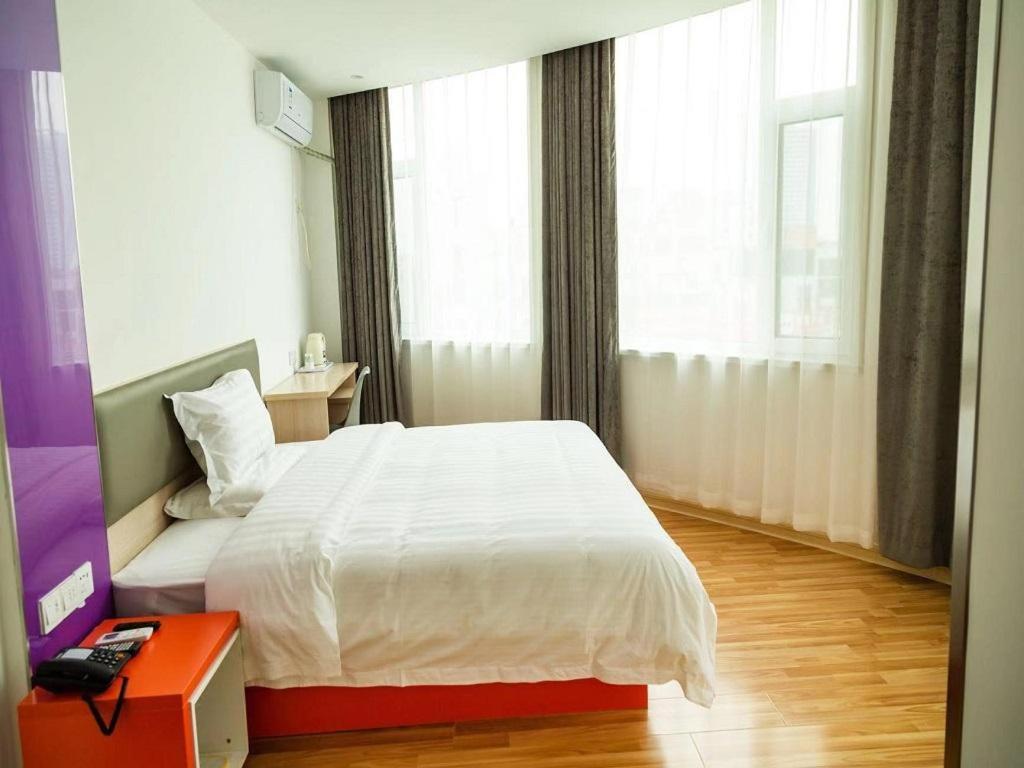 a bedroom with a white bed and a window at 7Days Inn Dongying Taihangshan Road Business Park Branch in Dongying
