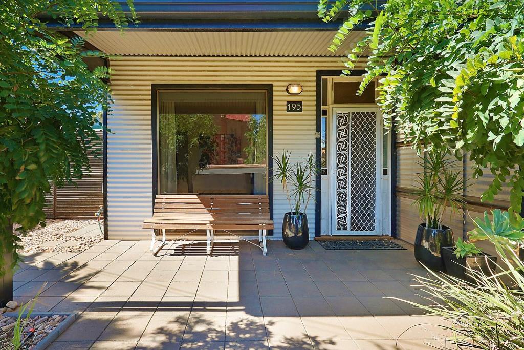 una panchina di legno seduta di fronte a una casa di Townhouse 3 a Broken Hill