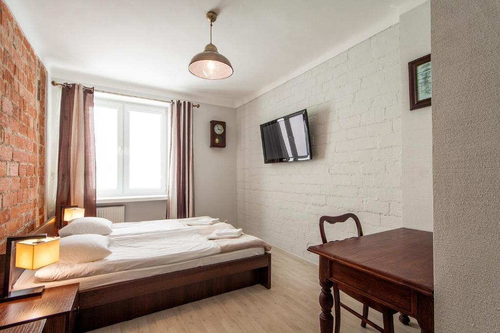 a bedroom with a bed and a desk and a window at Avion Hotel in Świdnik