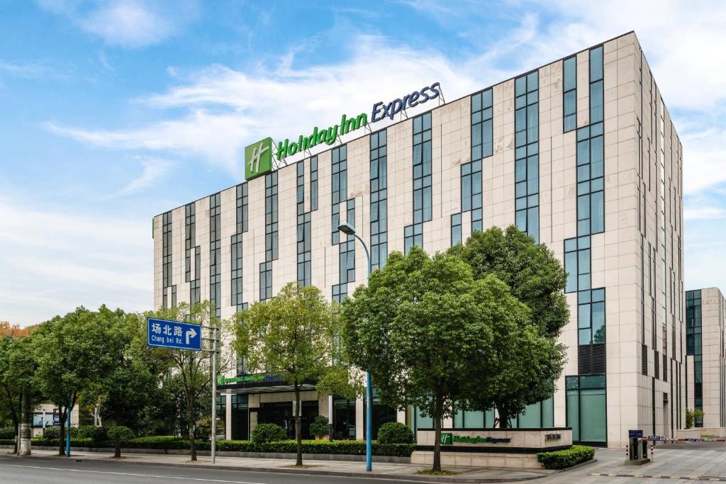 a large building with a sign on top of it at Holiday Inn Express Shanghai Gongkang, an IHG Hotel in Baoshan