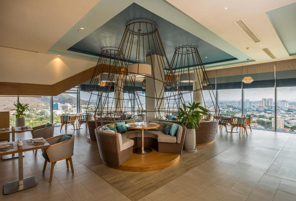 a hotel lobby with a chandelier and tables and chairs at Fusion Suites Vung Tau in Vung Tau