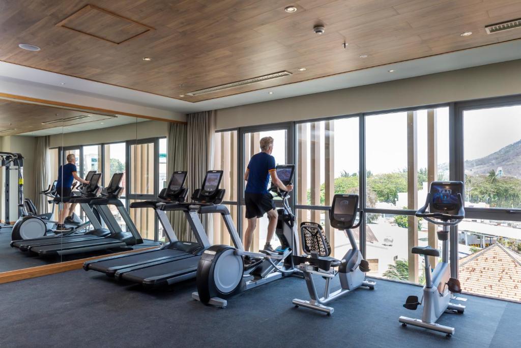 a hotel gym with cardio machines and windows at Fusion Suites Vung Tau in Vung Tau