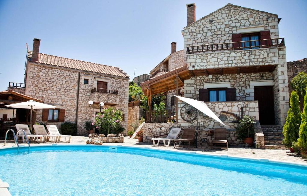 a villa with a swimming pool in front of a house at Tsivaras Villas in Tsivarás