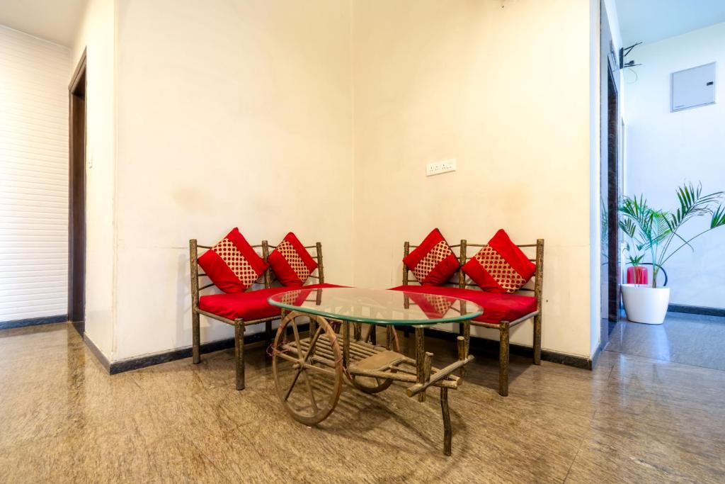 einen Tisch und Stühle mit roten Kissen in einem Zimmer in der Unterkunft Hotel Sunday Inn in Jaipur