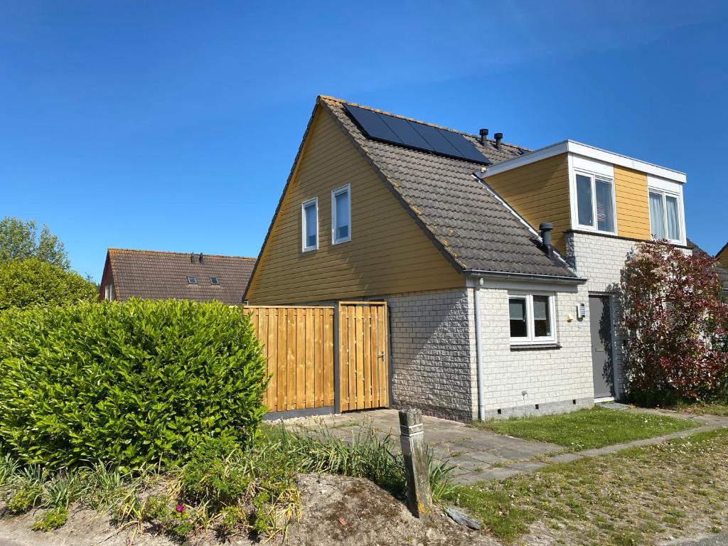 a house with a wooden fence in a yard at Oesterbaai 36 in Wemeldinge