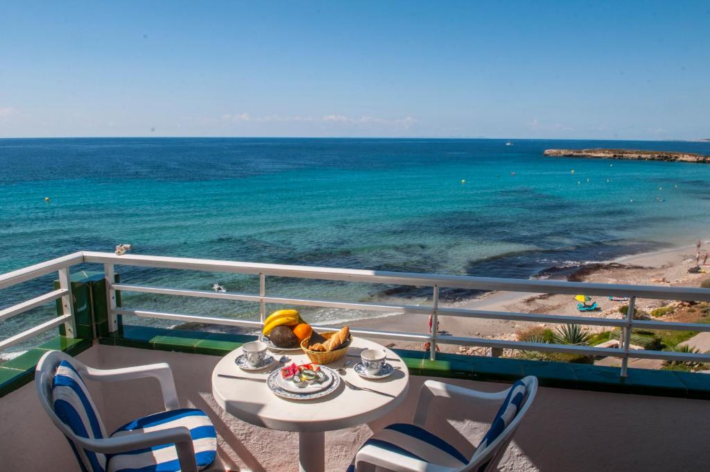 a balcony with a table and chairs and the ocean at Apartamentos Vistamar in Santo Tomás