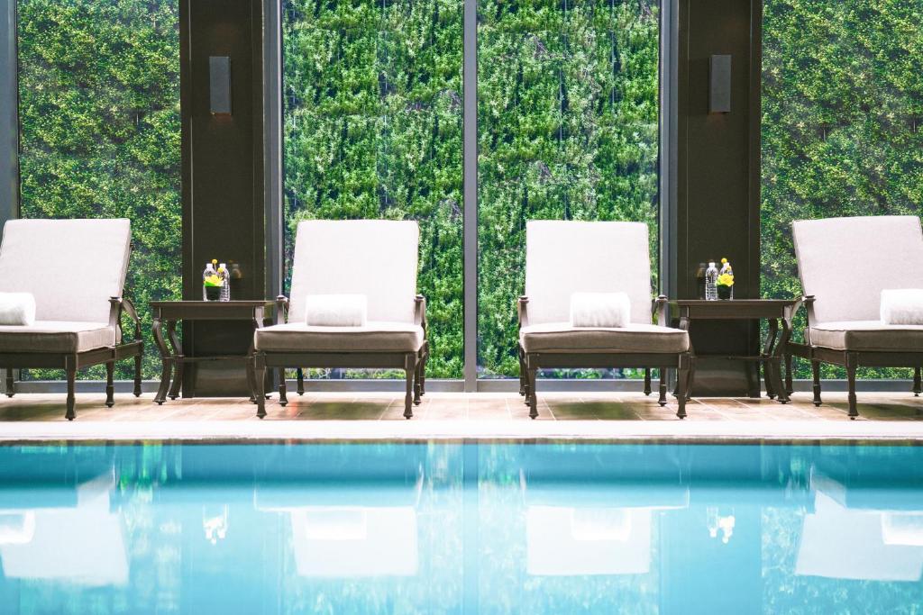 a group of chairs sitting next to a swimming pool at Pullman Shanghai Jingan in Shanghai