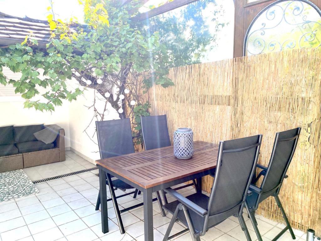 Une table et des chaises en bois sont disponibles sur la terrasse. dans l'établissement Apartment Bodman in Friedrichshafen, à Friedrichshafen