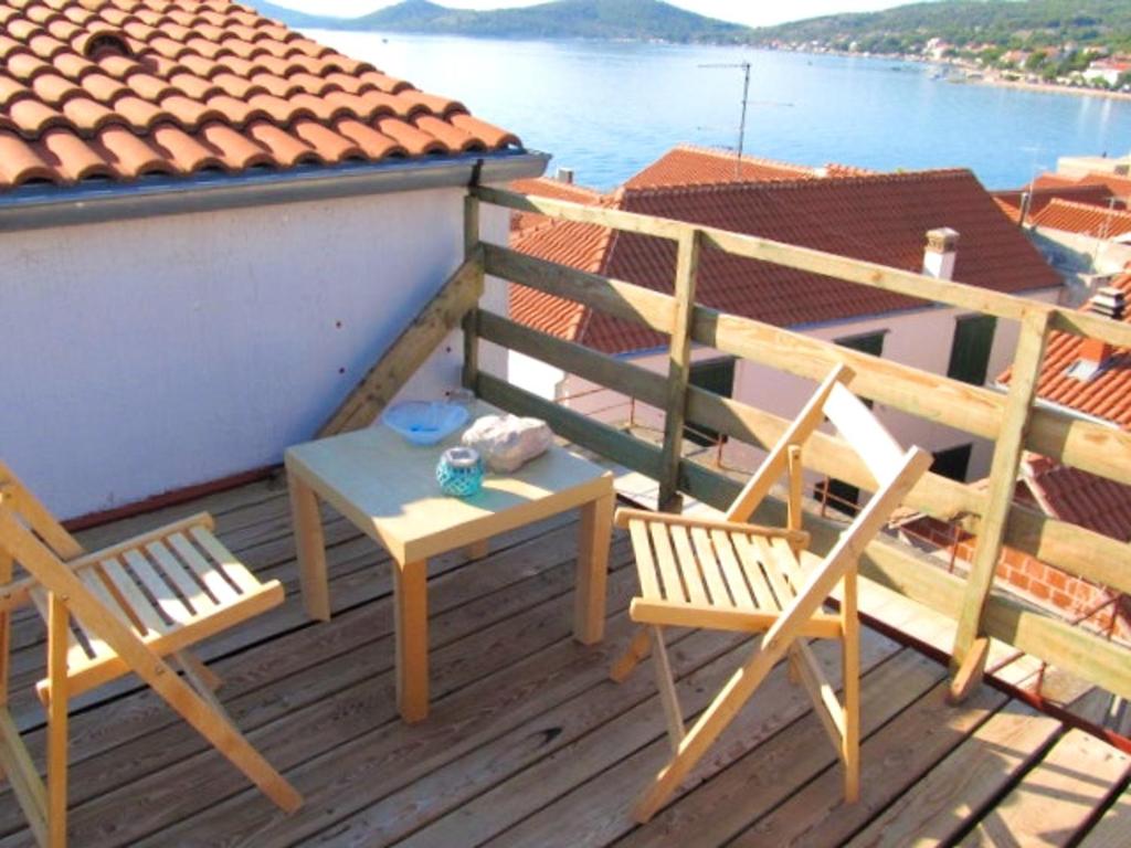 two chairs and a table on a deck with a view of the water at Modern Apartment Betina 45 m² + sea view in Betina