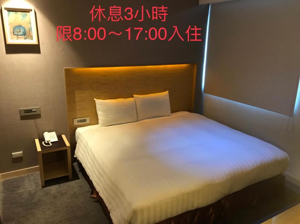 Postel nebo postele na pokoji v ubytování 麗馨商旅七賢館