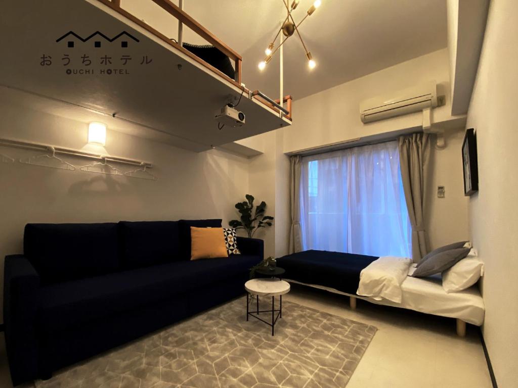 OUCHI HOTEL Higashi-Hiratsuka #302 في هيروشيما: غرفة معيشة مع أريكة ونافذة