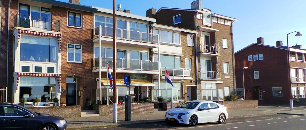 una macchina bianca parcheggiata di fronte a un edificio di Hotel B&B Seahorse a Katwijk