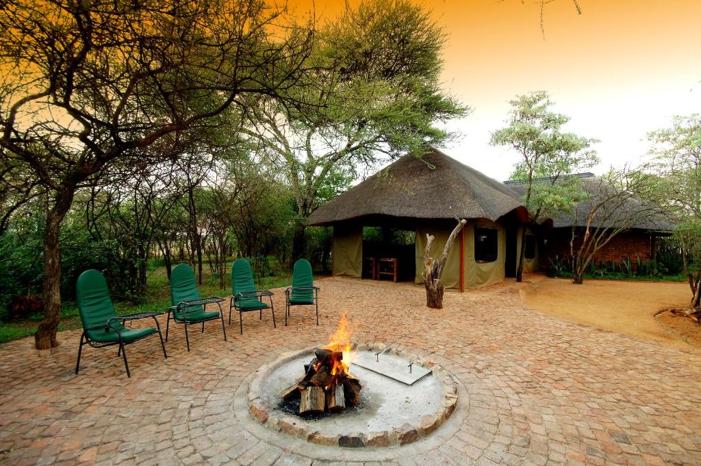 a fire pit with chairs and a gazebo at Sondela Nature Reserve & Spa Moselesele Tents in Bela-Bela