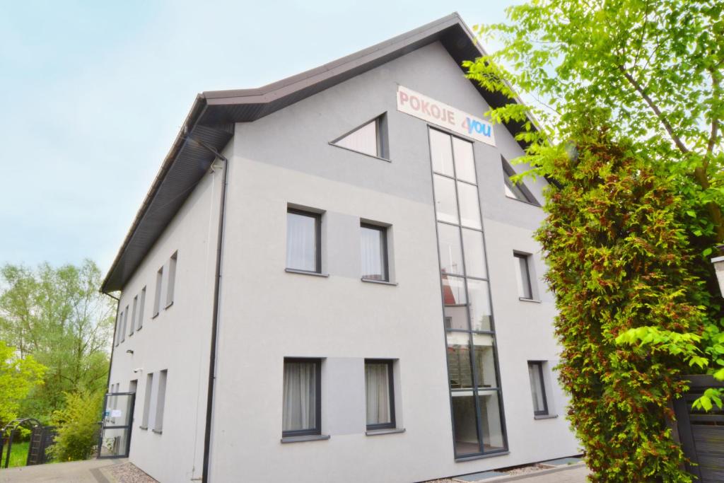 a white building with a street sign on it at Pokoje 4you Szczecin in Szczecin