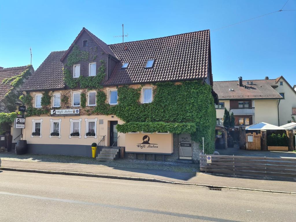 a building covered in ivy on the side of a street at Gasthof Wolfs Stuben in Reichenbach an der Fils