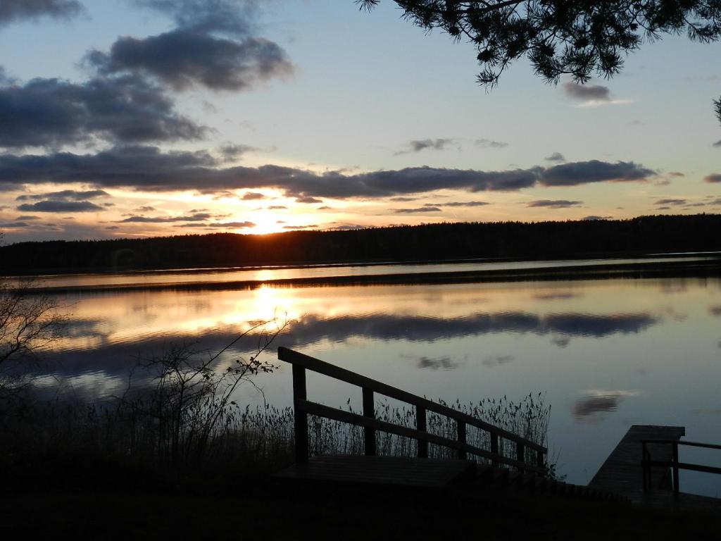 a bench sitting in front of a lake at sunset at Labbnäs Semesterhem in Kimitoön