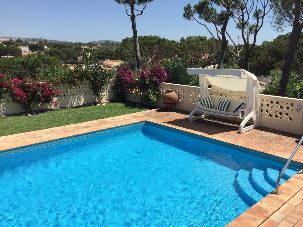 uma piscina com uma espreguiçadeira e uma cadeira num quintal em 4 bedrooms villa with private pool enclosed garden and wifi at Vilamoura 3 km away from the beach em Vilamoura