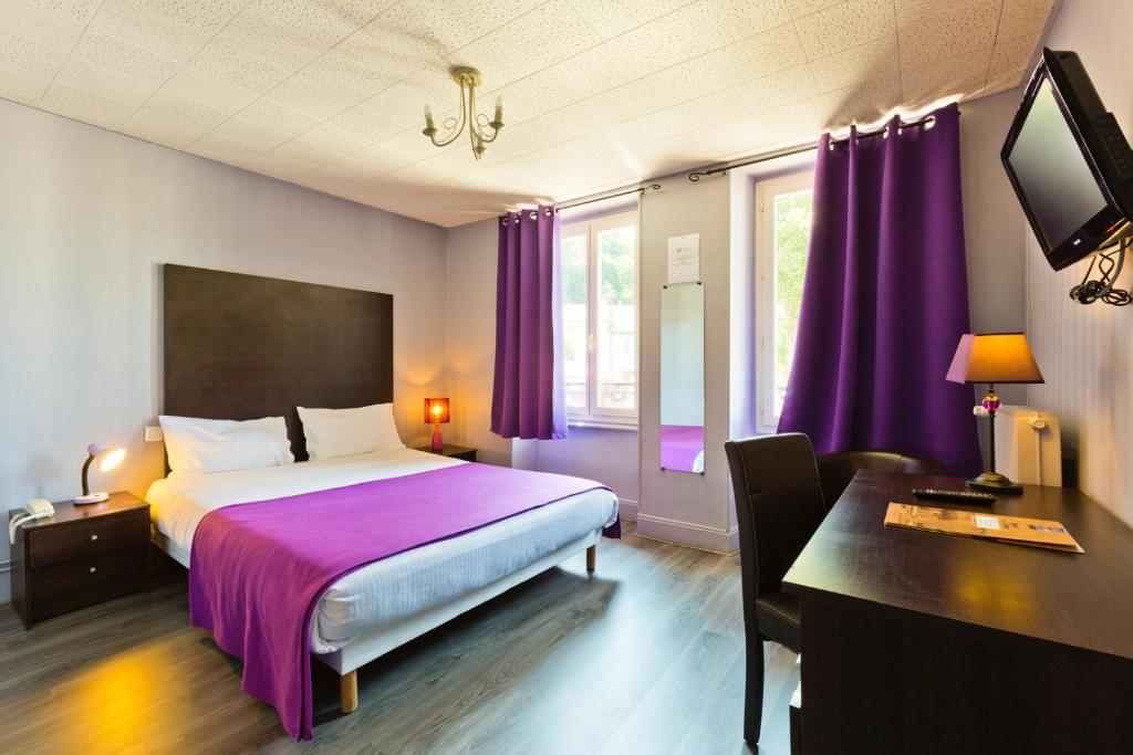 1 dormitorio con cama, escritorio y cortinas moradas en Logis Hotel restaurant de la Poste, en Pontgibaud