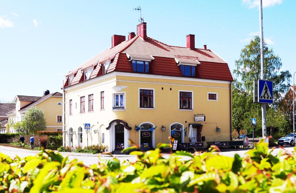 a large yellow building with a red roof at Kågeröds Värdshus Tre Stjärnor in Kågeröd