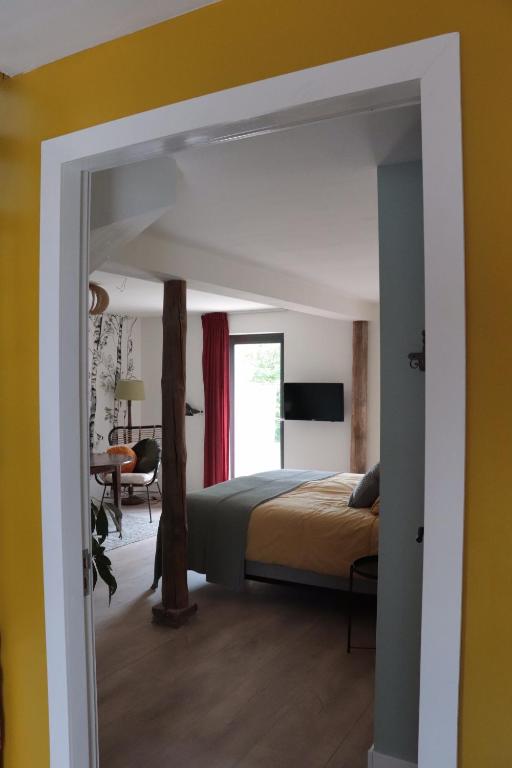 a bedroom with a bed and a desk in a room at Kade10Buren in Buren