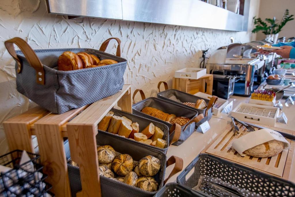 eine Bäckerei mit mehreren Tabletts mit Brot und Gebäck auf einer Theke in der Unterkunft Park Hotel Diament Katowice in Kattowitz