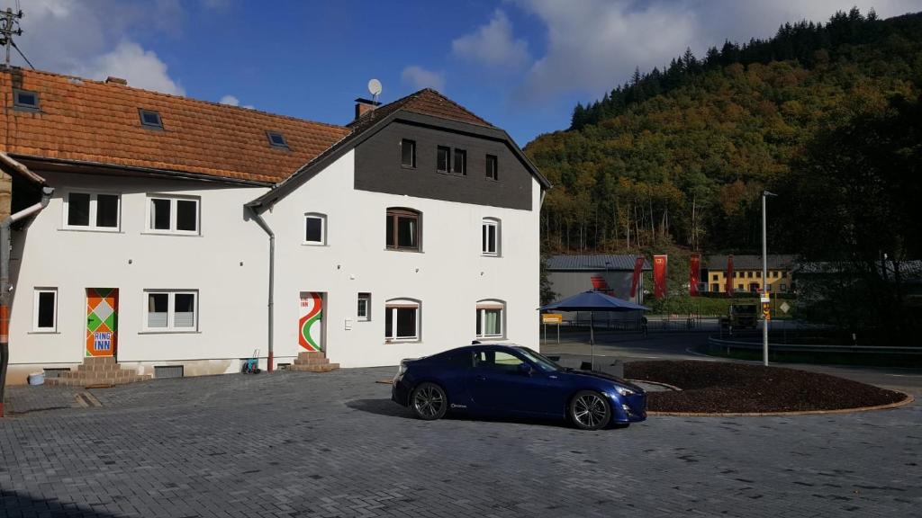 a blue car parked in front of a white building at The Ring Inn in Adenau