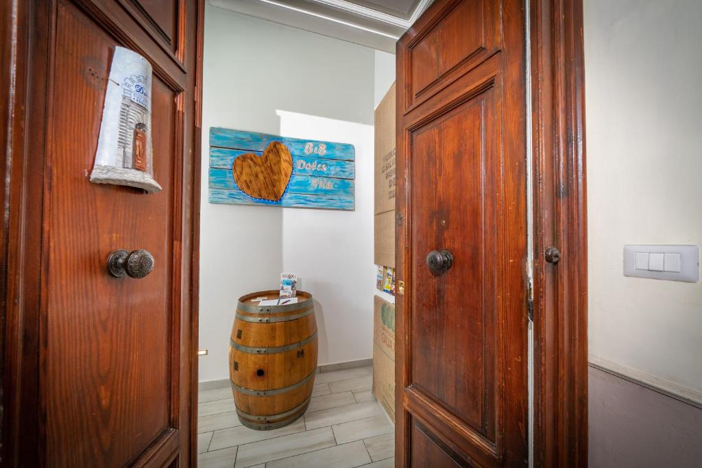 un pasillo con una puerta de madera y un barril en B&B DolceVita Napoli, en Nápoles
