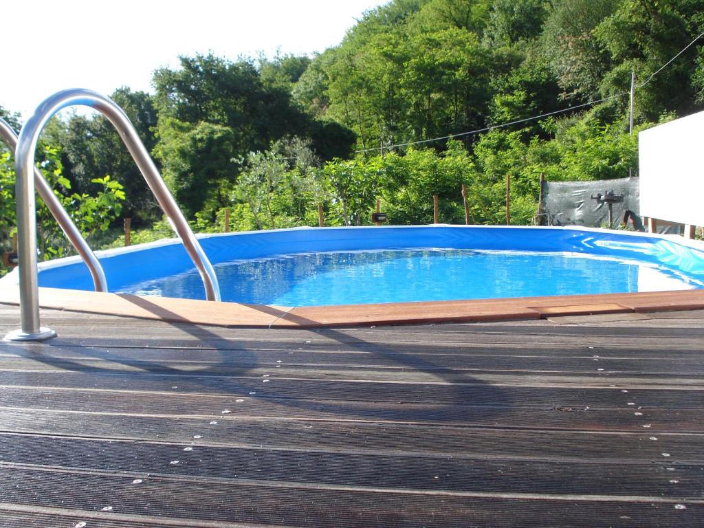 uma piscina com água azul e um deque de madeira em Casa Vacanze Lillo em Vezzano Ligure