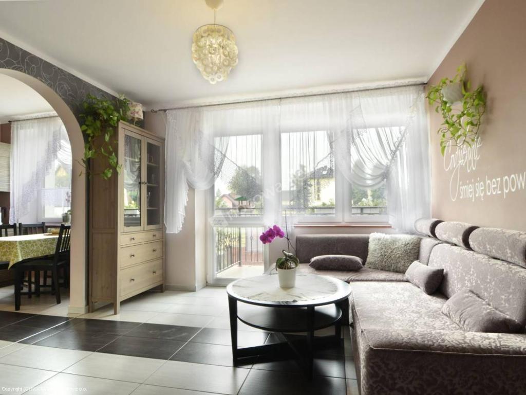 Apartamenty Rodzinne في كودوفا زدروي: غرفة معيشة مع أريكة وطاولة