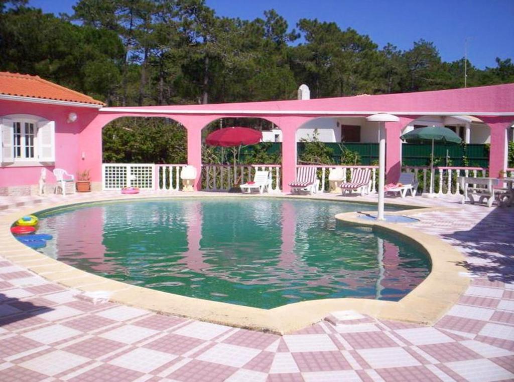 una casa rosa con piscina frente a ella en 3 bedrooms apartement with shared pool enclosed garden and wifi at Sintra 3 km away from the beach, en Sintra