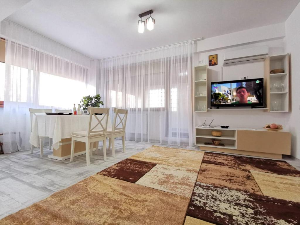 a living room with a television and a dining room table at Cappuccino Apartment-Brilliant Apartments in Constanţa