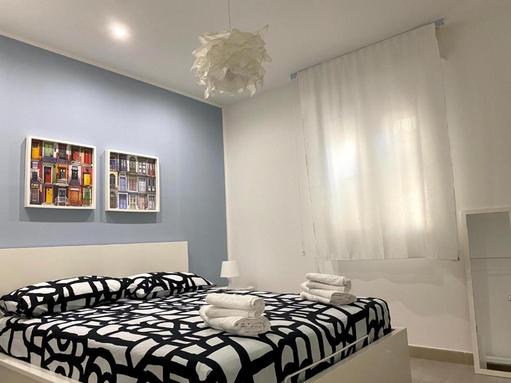 a bedroom with a black and white bed and a window at Appartamento D & D in Niscemi