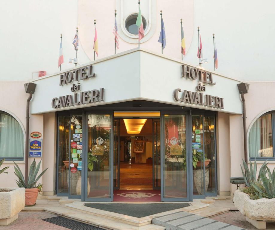 a store front of a building with flags in front at Best Western Hotel Dei Cavalieri in Barletta