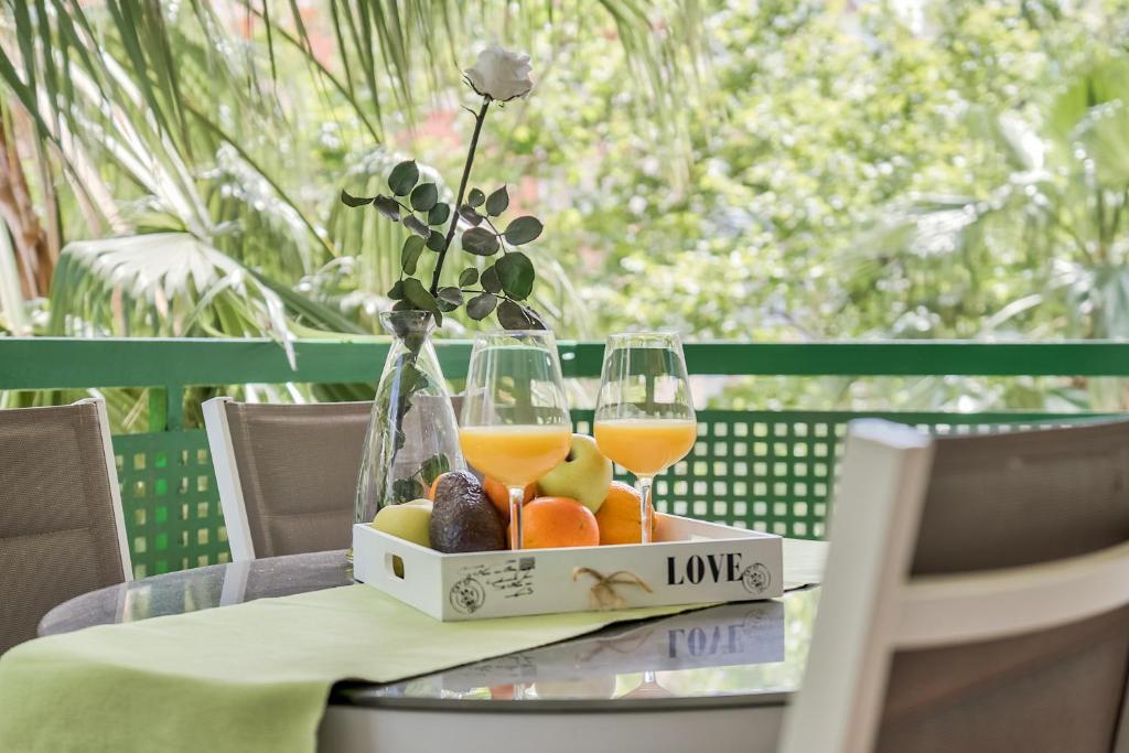 una bandeja de frutas y copas de vino en una mesa en Sur Suites Pauli, en Fuengirola