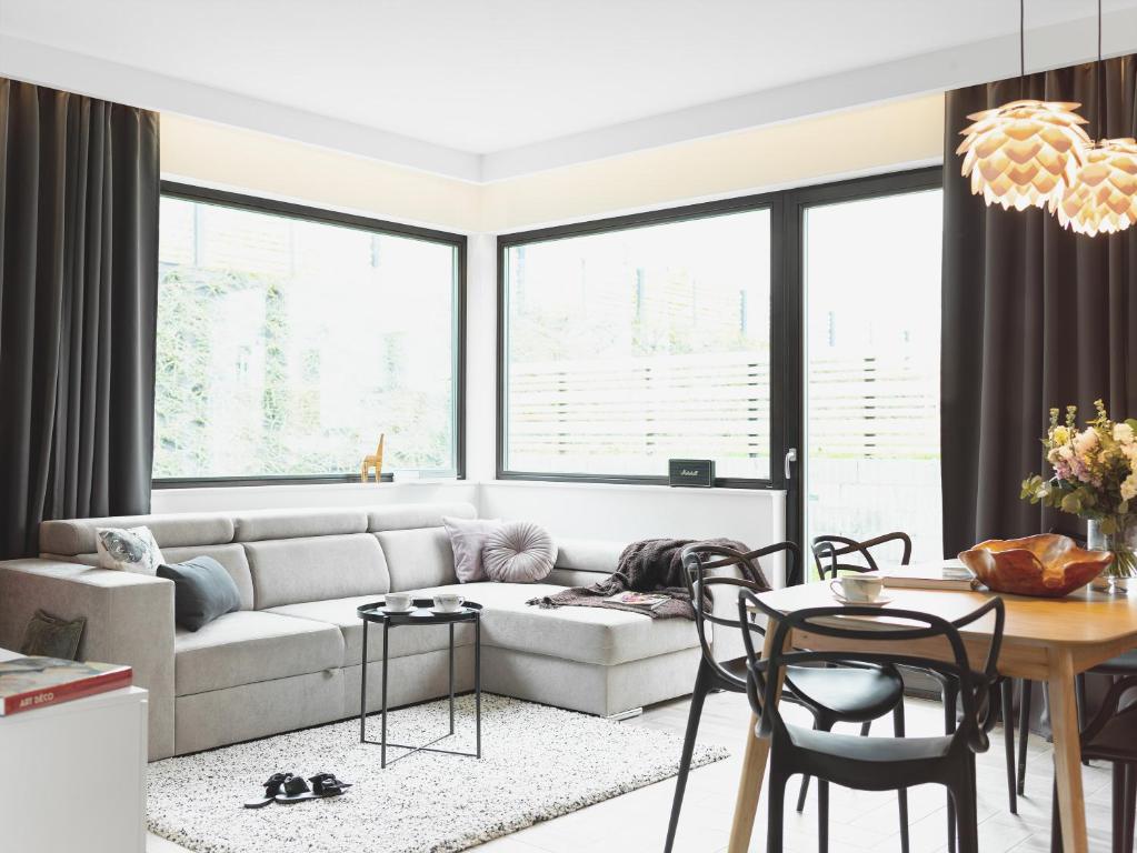 a living room with a couch and a table at Apartament Nadmorski z ogródkiem i sauną in Mechelinki