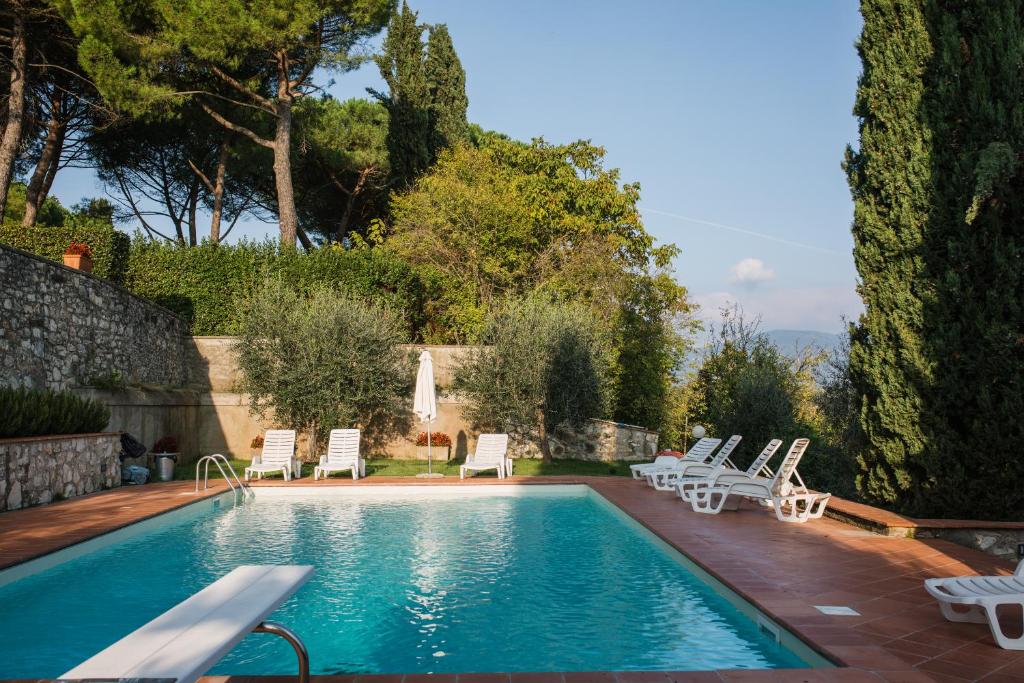 a swimming pool with lounge chairs and a swimming pool at Fattoria Pagnana Suites & Pool in Rignano sullʼArno