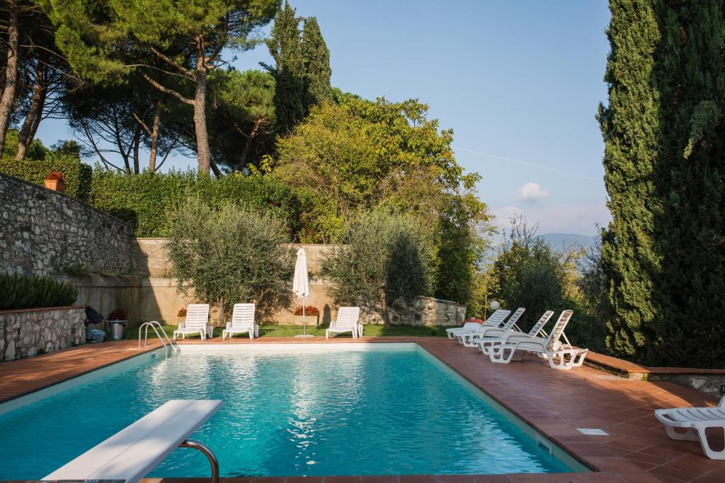 una piscina con tumbonas y una piscina en Fattoria Pagnana Suites & Pool, en Rignano sullʼArno