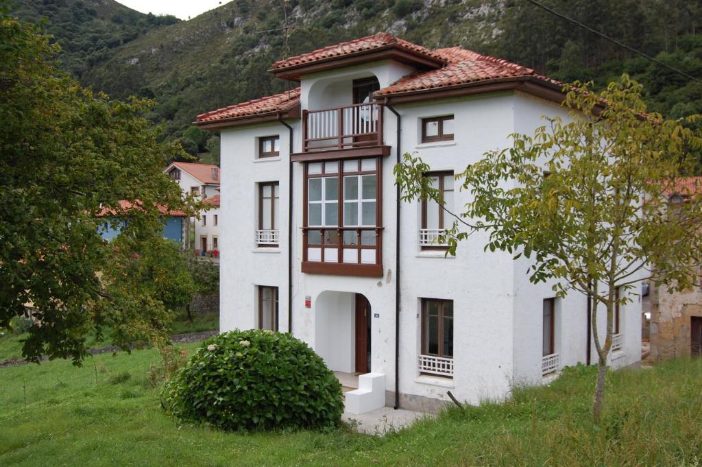 une maison blanche avec un toit rouge dans l'établissement La Casona de Narganes, à Narganes