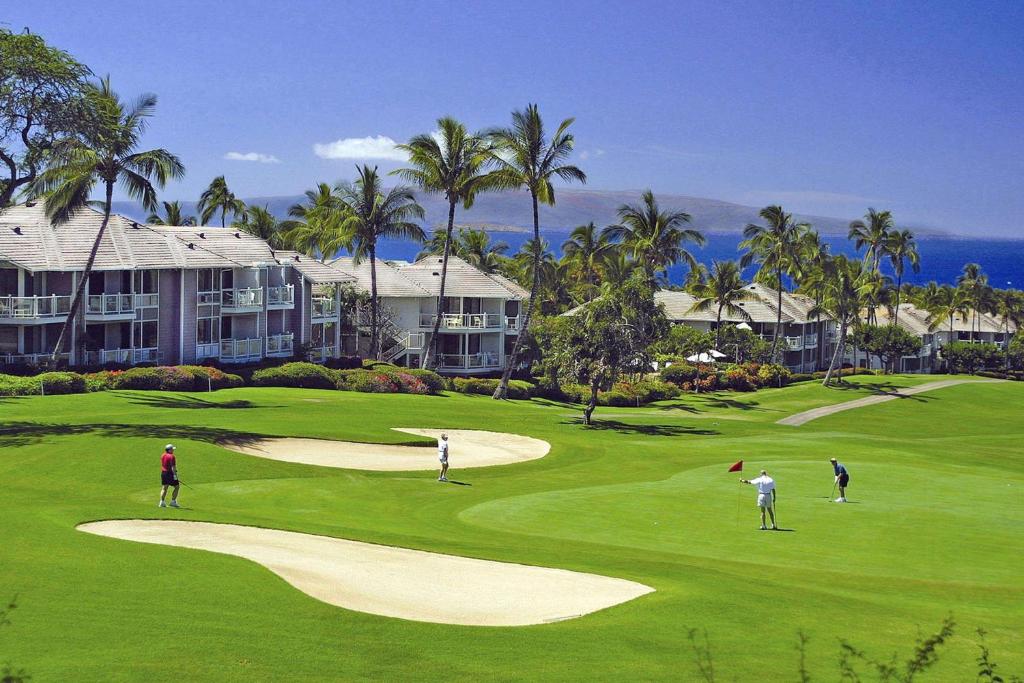 a group of people playing golf on a golf course at Wailea Grand Champions Villas - CoralTree Residence Collection in Wailea