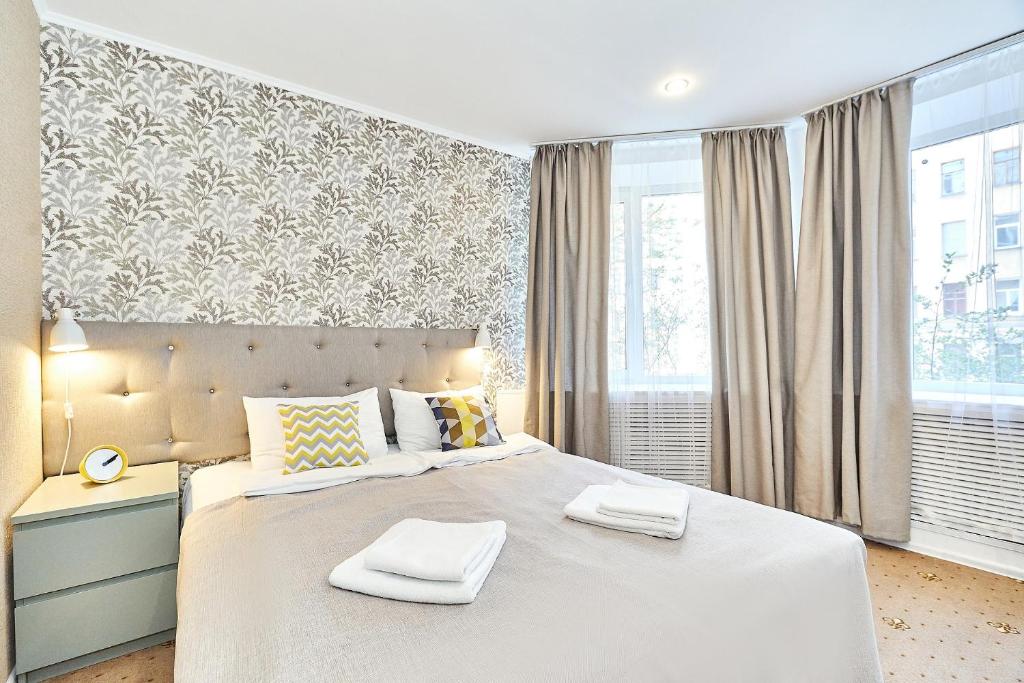 um quarto com uma cama grande com duas toalhas em Seven Bridges Hotel em São Petersburgo