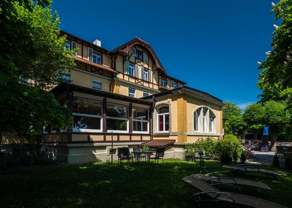 a large yellow building with chairs in front of it at Waldhaus Jakob in Konstanz