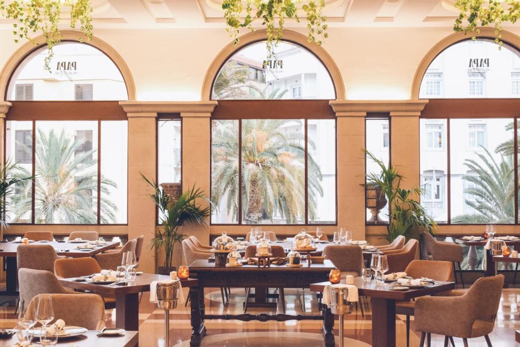 a dining room with tables and chairs and windows at Iberostar Heritage Grand Mencey in Santa Cruz de Tenerife