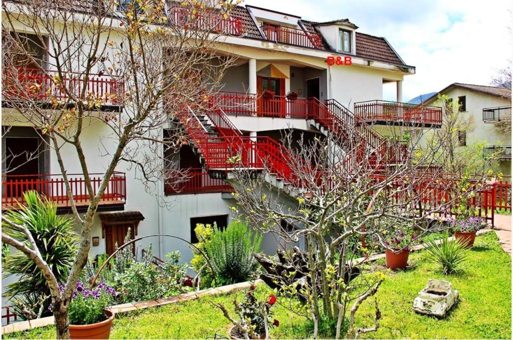 ein Gebäude mit roten Balkonen und einem Hof mit Pflanzen in der Unterkunft One bedroom apartement with wifi at Calvello in Calvello