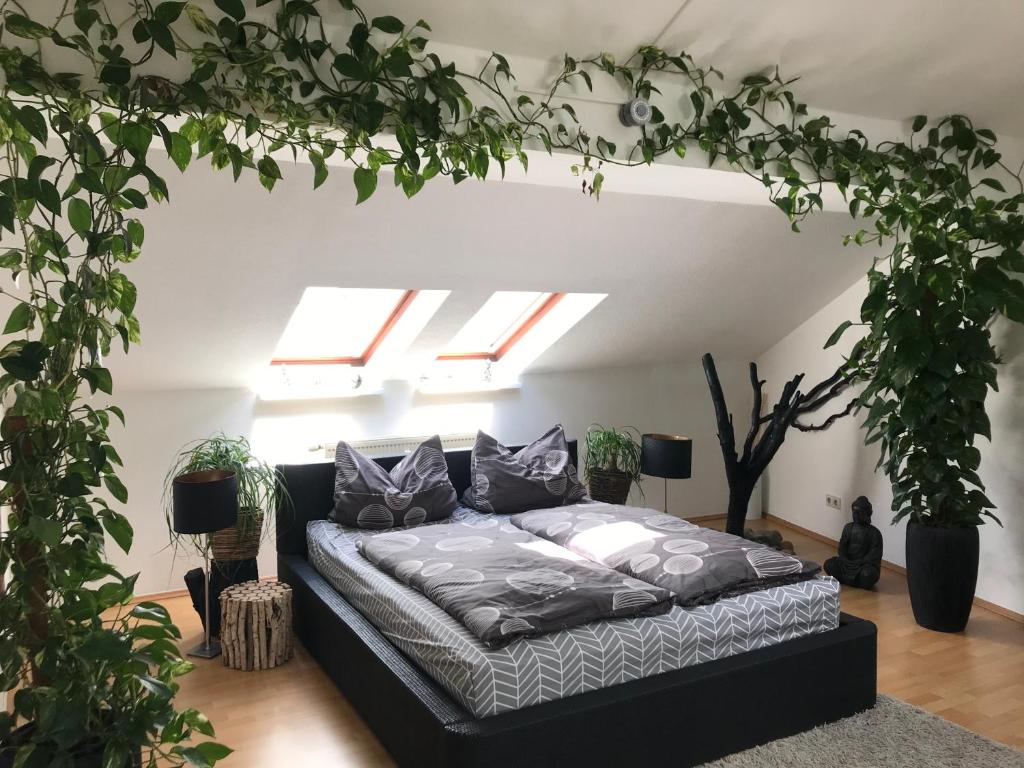 ein Schlafzimmer mit einem Bett in einem Zimmer mit Pflanzen in der Unterkunft Stadtdschungel FeWo mit Balkon in Cottbus