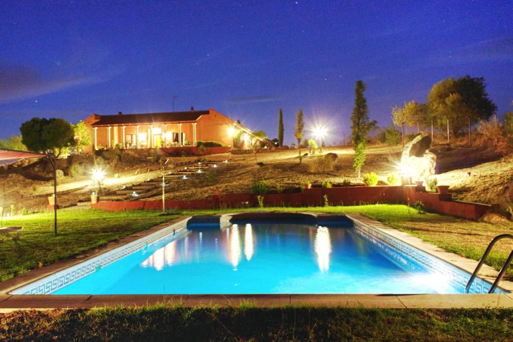 - une piscine en face d'une maison la nuit dans l'établissement Villa Romana- hasta 24 personas, à Don Álvaro