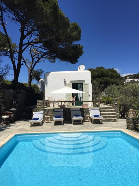 a swimming pool with chairs and a house at Andromeda in Exámbela