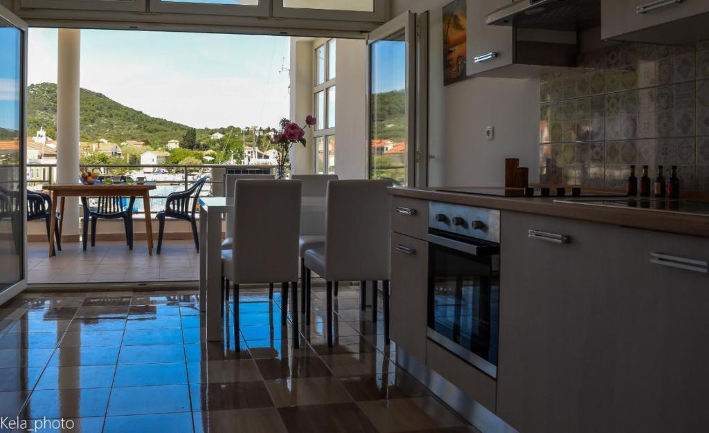 a kitchen with a view of a table and chairs at Galeb in Veli Iž