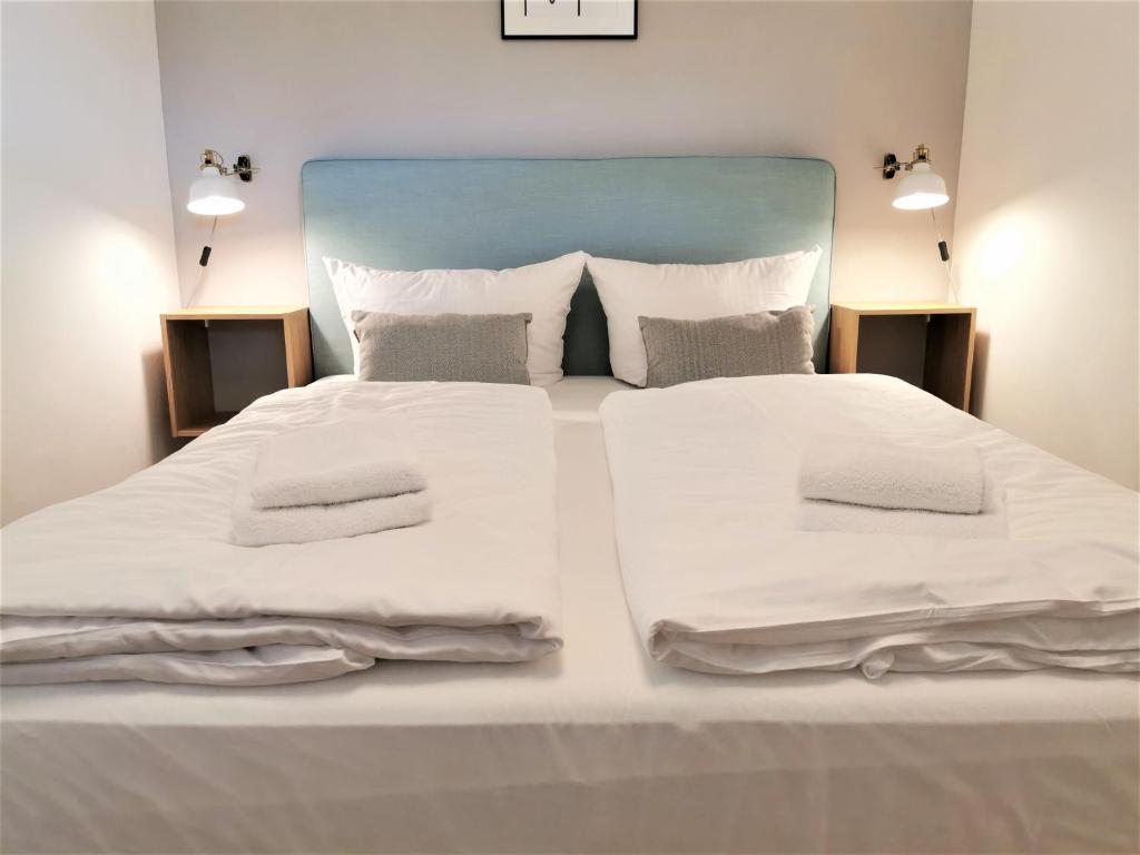 ein großes weißes Bett mit weißer Bettwäsche und Kissen in der Unterkunft 2minBikepark&Ski - Loft Lotte - bikes lockable in Winterberg