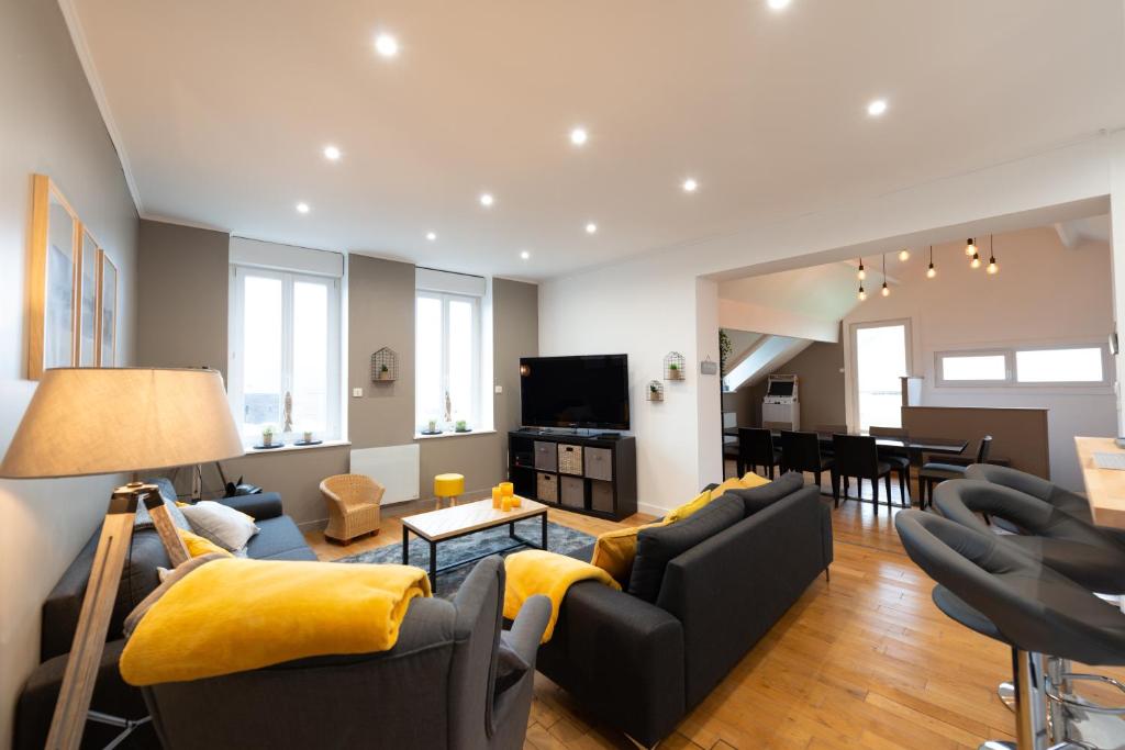 a living room with two couches and a television at Maison à 2 pas du Port et du marché d'Etaples in Étaples
