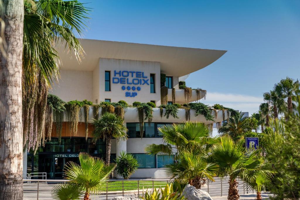 un edificio de hotel con palmeras delante en Hotel Deloix 4* Sup, en Benidorm